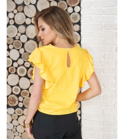 Жовта блуза з вирізами і воланами