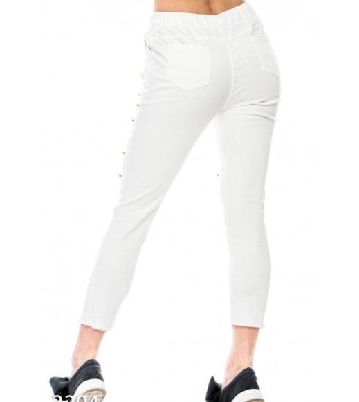 Білі джинсові брюки з прорізами і намистинками
