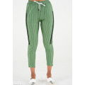 Зелені в смужку завужені брюки з тасьмою по боках
