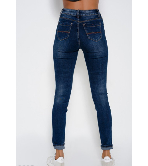 Синие эластичные зауженные джинсы с декоративными швами на задних карманах и потертостями