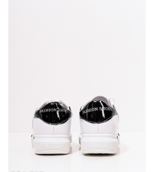 Білі кросівки з чорними лакованими листочками