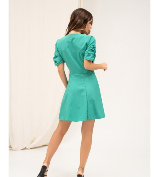 Зеленое платье со сборками и декольте