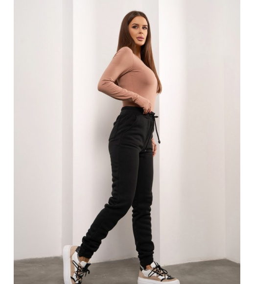 Чорні штани з асиметричними манжетами.