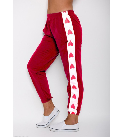 Красные свободные спортивные штаны с вставками по бокам принтованными сердечками